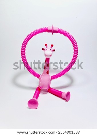A colorful and playful pink giraffe toy featuring a flexible ring. Ideal for stimulating creativity and fun during children's playtime, providing both entertainment and imaginative engagement.