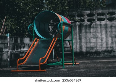 A colorful playground slide and climbing structure stands alone in a dimly lit courtyard.
 - Powered by Shutterstock