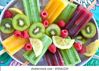Colorful popsicles with fresh fruits in vintage tray