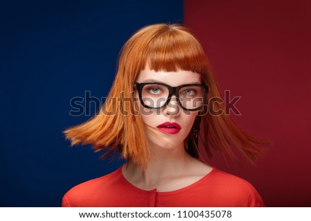 Colorful portrait of redhead young beautiful woman. Girl wearing fashionable eyeglasses.
