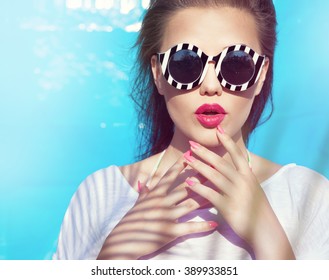 Colorful portrait of young attractive woman wearing sunglasses. Summer beauty and nail art concept - Powered by Shutterstock