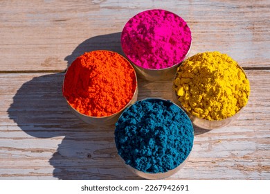 Colorful powder organic Gulal colors in bowls for Indian Holi festival. Wooden background. High quality photo - Shutterstock ID 2267942691