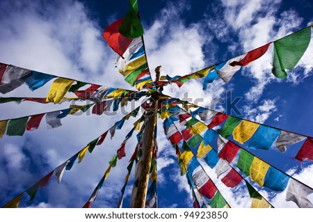 colorful prayer flag in tibet under blue sky and white cloud