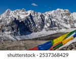 Colorful prayer flags with mantra written on it in the Himalayas mountains in Nepal on the summit of Himalaya muntain peak. Nepali and tibetian red, yello, blue, green and white flags