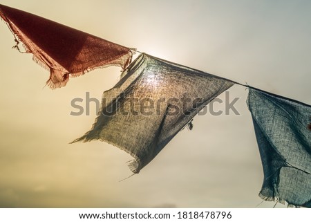 Colorful prayer flags with sun shining through one of prayer flags