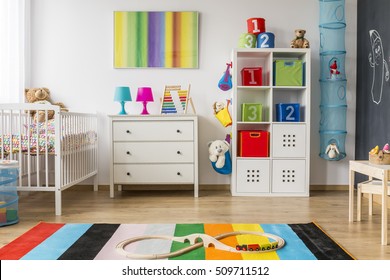 Colorful And Pretty Child Room With Chest Of Drawers And Cradle