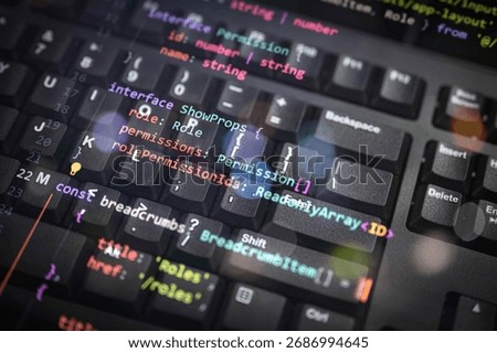Colorful programming interface code overlay on black keyboard, showcasing software architecture, permissions, and user role systems in modern web development and secure application environments.