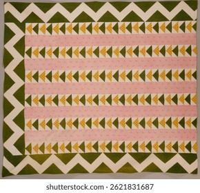 Colorful quilt with zigzag pattern. Quilt features pink, green, and yellow triangles. Zigzag quilt design with vibrant colors. Quilt art with geometric shapes. Vintage decorative pattern artwork.