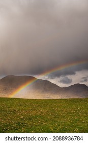 Colorful Rainbow Over Green Field In Connemara, Ireland. Mountains In The Background. Irish Landscape. Cloudy Sky. Nobody
