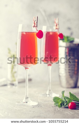 Colorful Red exotic alcoholic cocktail in champagne glasses over gray background