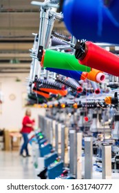 Colorful reel thread set up at modern and automatic sewing or embroidery spinning machine, textile industry factory concept 
