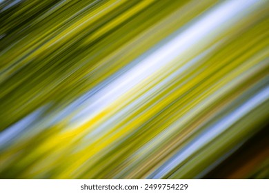 Colorful reflections of a forest in the sunshine on a chrome-plated surface. Linear structures through distortion in the colors green, blue, turquoise, white and yellow. Abstract dynamic background.