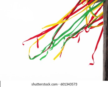Colorful ribbons on a pole. Long tapes are fluttering in the wind. Red, yellow and green ribbons on a holiday, Shrovetide. Ethnic isolate on white background