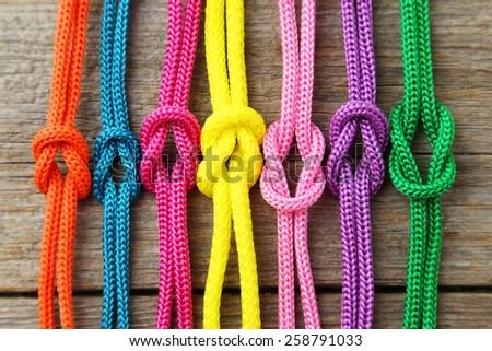 Colorful ropes on grey wooden background