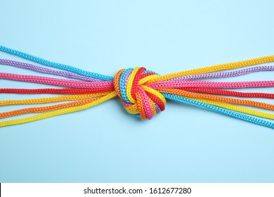 Colorful Ropes Tied Together On Light Blue Background, Top View. Unity Concept