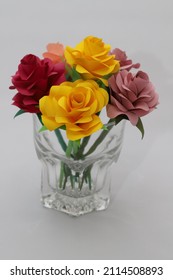 Colorful rose flowers made of origami decorated in a transparent grass.