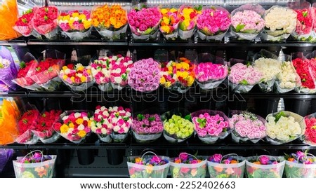 Colorful roses bouquet wall display in front of flower shop. Flower arrangements for sale at local florist