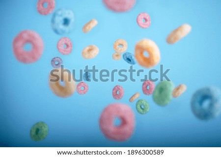 Colorful round cereals in levitation on a blue background. Colorful breakfast food. High quality photo