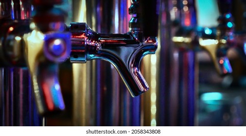 Colorful Row of Silver Taproom Beer Faucets in Club Dive Bar