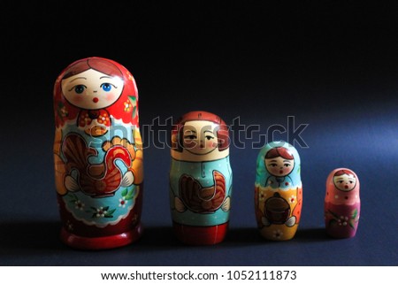 Colorful Russian Matryoshka nesting dolls on black background. Space for design and writing.