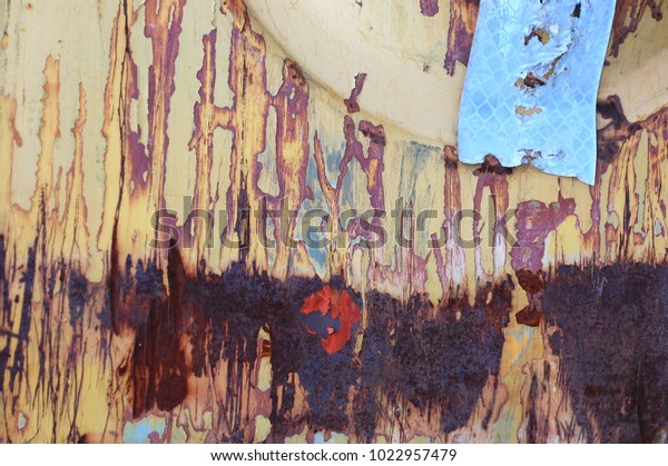 Colorful rusty metal abstract from detail of beat\
up and dented  construction machinery. Interesting grunge\
texture