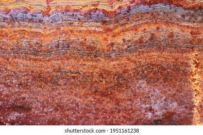 colorful rusty metal surface divided into layers or strata as geological creating organic shapes - worn abstract background for a wallpaper