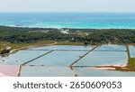 Colorful salt evaporation ponds bordering turquoise waters near es trenc natural beach in mallorca, balearic islands, spain