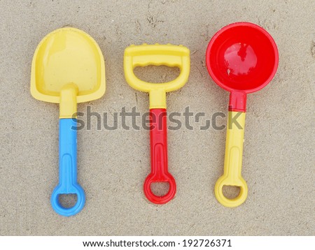 colorful sand castle toys - spoon, fork and spade on beach