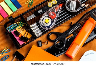 colorful school and office supplies on an orange background