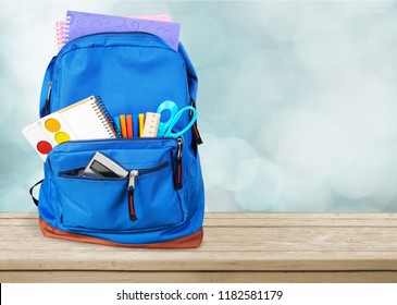 Colorful school supplies in backpack on wooden - Shutterstock ID 1182581179
