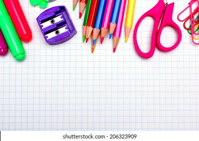 Colorful School Supplies Border Over Graphing Paper 