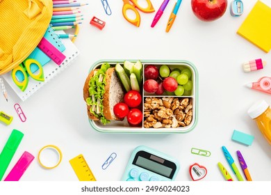 Colorful School Supplies and Healthy Lunchbox. Top view of vibrant school supplies arranged around a nutritious lunchbox with sandwich, fruits, and nuts. Back-to-school, education, nutrition concept. - Powered by Shutterstock