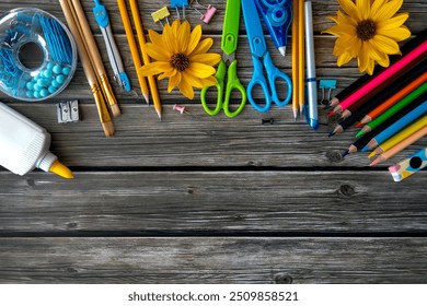 Colorful School Supplies and Sunflowers on Wooden Background. A vibrant collection of school supplies, including pencils, scissors, colored pencils, glue, and paper clips, arranged on a rustic wooden - Powered by Shutterstock