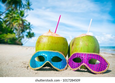 Colorful sequined carnival masks and fresh green coconut drinks on a palm fringed beach in Brazil