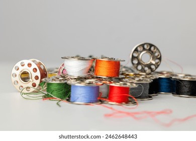 Colorful sewing bobbins on a bright background - Powered by Shutterstock