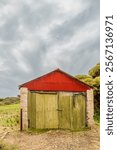 A colorful shed that used to be a chalk factory, but is now abandoned in the historic mining town of Inneston on the Yorke Peninsula in South Australia where it is shown under an overcast sky.