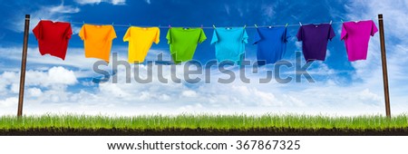 colorful shirts on washing line on green meadow