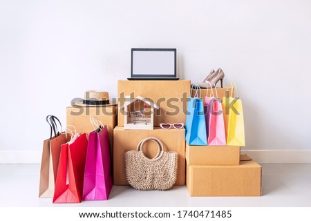 Colorful shopping bag with stack of cardboard boxes and fashion items at home, Website online shopping concept with copy space