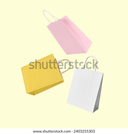 Colorful shopping bags falling on beige background
