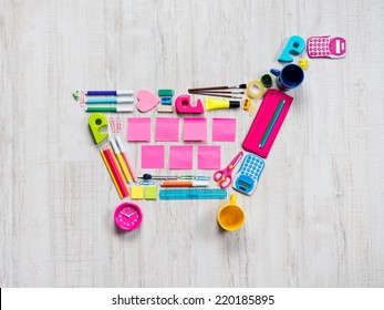 Colorful Shopping Cart Composed Of Stationery And Office Objects.