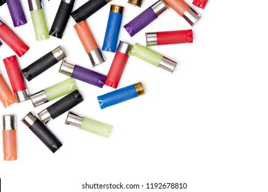 Colorful shotgun shells on a blank (white) background, arranged on top left corner, with copy space. Top view.