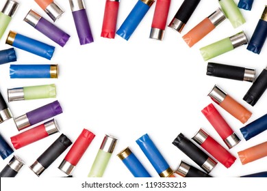 Colorful shotgun shells on a blank (white) background, with a copy space in the center. Top view.