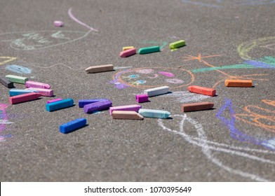 Colorful Sidewalk Chalk Art, Specifically Chalk Drawings By Kids Playing Outside Of The School Yard On A Sunny Summer Day.