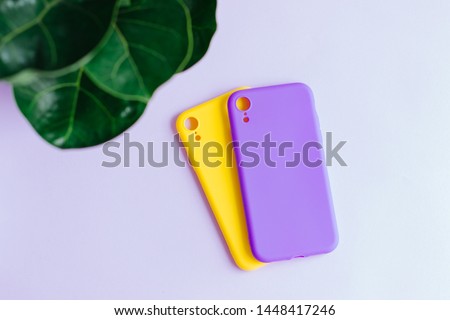 Colorful silicone cases for your smartphone. Bright yellow and purple silicone cases for smartphone. Flat lay.