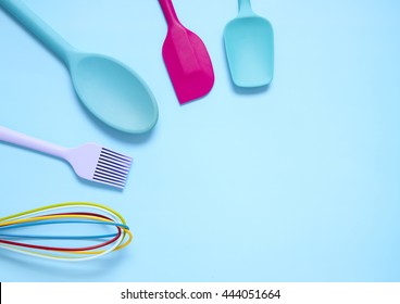 Colorful Silicone Cooking Utensils On A Blue Background Forming A Page Border