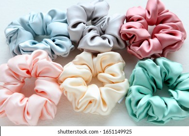 Lot of Colorful silk Scrunchies on white. Flat lay Hairdressing tools and accessories. Hair Scrunchies, Elastic HairBands, Bobble Sports Scrunchie Hairband