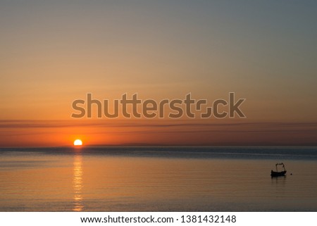 Colorful sky and boat at sunup