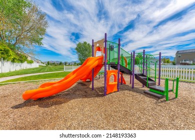 Colorful Slides In A Community Playground With Picket Fence At Utah Valley