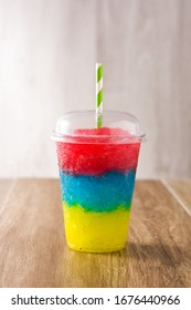 Colorful Slushie Of Different Flavors With Straw In Plastic Cup Isolated On White Background.