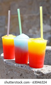 colorful slushy ice drinks in plastic cups